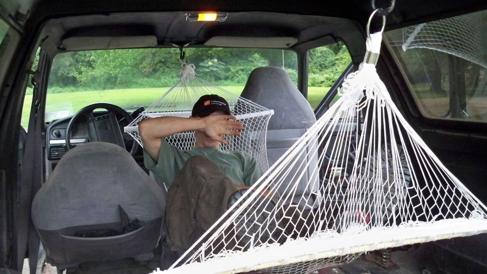 guy chilling in a hammock inside a vehicle