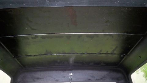 1994 Ford Bronco - The interior ceiling of a vehicle shows horizontal paneling and signs of water damage.