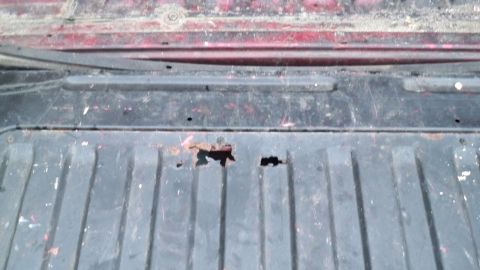 1994 Ford Bronco - The bed of a truck shows significant rust and damage, with holes exposing the metal beneath.