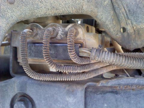 1996 Ford Bronco - This image shows a close-up of a vehicle's brake component, with visible wiring and hoses.