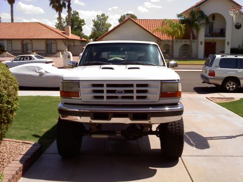 1996 Ford Bronco - This 1996 Ford Bronco is shown from the front, parked in a driveway with houses in the background.