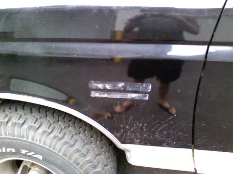 1990 Ford Bronco - Close-up of a vehicle's side panel, revealing tire and trim details.