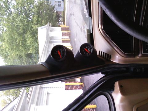 1990 Ford Bronco - Close-up of aftermarket gauges installed inside a vehicle's cabin.
