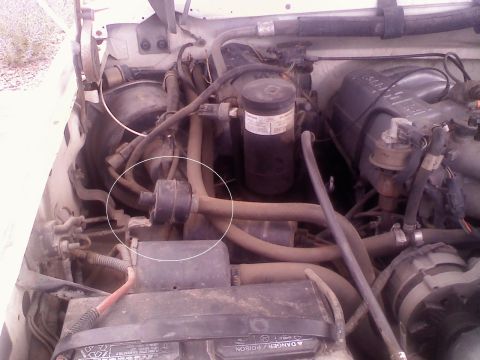 1996 Ford Bronco - Close-up view of a vehicle's engine bay, showing various hoses and mechanical parts.