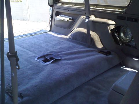 1994 Ford Bronco - The interior cargo area of a 1994 Ford Bronco shows gray carpeting and a seatbelt.
