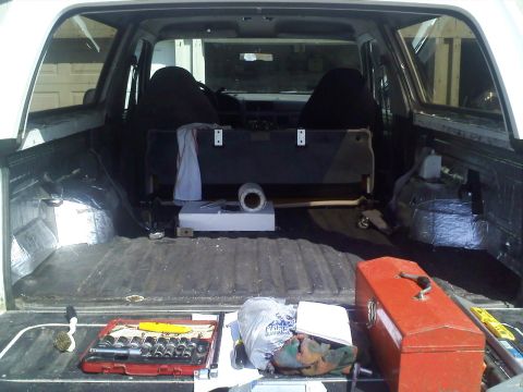 1994 Ford Bronco - Tools and supplies are organized in the cargo area of a white SUV.