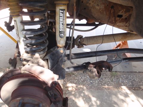 1994 Ford Bronco - Undercarriage view shows suspension and drivetrain parts, including Superlift shocks and a driveshaft.