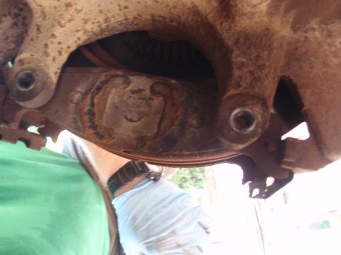 1994 Ford Bronco - A close-up view of a rusty vehicle suspension component, likely part of the balljoint assembly.