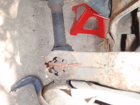 1994 Ford Bronco - A close-up view of a vehicle's ball joint assembly, showing signs of rust and wear, with a red jack stand visible.
