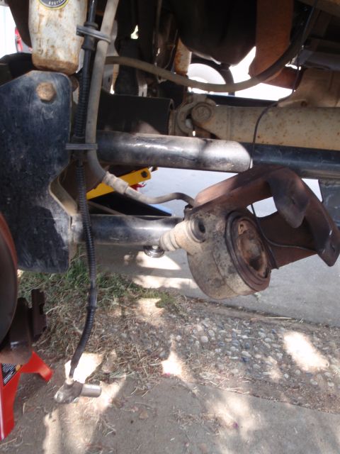 1994 Ford Bronco - Close-up of a vehicle's suspension system, showing a worn ball joint assembly.