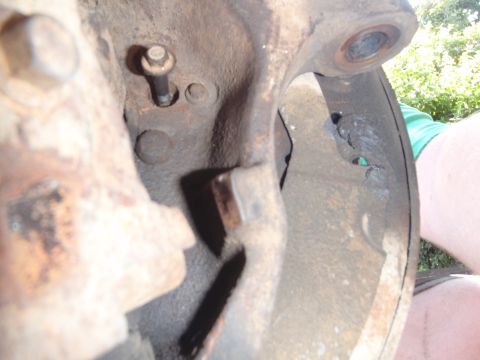 1994 Ford Bronco - This is a close-up view of a rusty vehicle suspension component, likely a ball joint assembly.