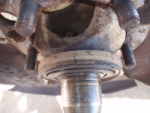 1994 Ford Bronco - This image shows a close-up of a vehicle's ball joint assembly, highlighting a cracked seal and surrounding rusty metal components.