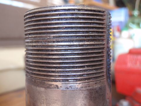 1994 Ford Bronco - A close-up view of a threaded metal component, likely a vehicle part, with visible wear and dirt.