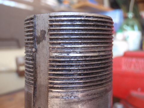 1994 Ford Bronco - A close-up view of a threaded metal component, showing signs of wear and lubrication.