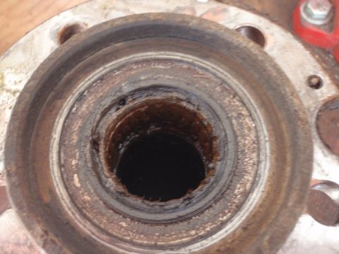 1994 Ford Bronco - Close-up view of a heavily worn wheel bearing hub, showing significant rust and damage to the inner race.