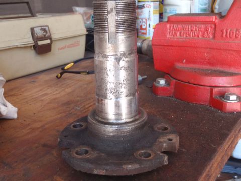 1994 Ford Bronco - A close-up view of a worn wheel hub assembly, likely for a truck or SUV, held in a vise.