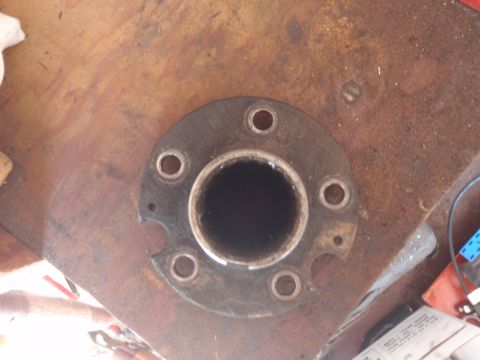 1994 Ford Bronco - Close-up view of a flanged hub with six bolt holes, resting on a wooden surface.
