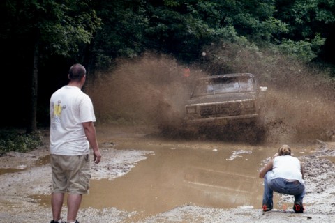 1979 Ford Bronco II - 1979 Ford Bronco II navigates a challenging muddy terrain, creating a large splash.