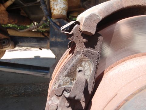 1994 Ford Bronco - This photo shows a worn brake caliper and rotor, likely needing replacement.