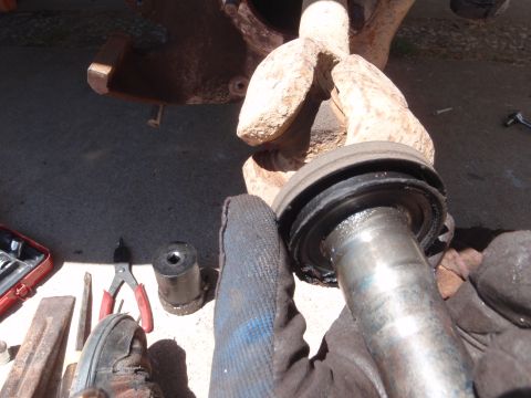 1994 Ford Bronco - Close-up of a ball joint assembly being held, with various tools scattered nearby.