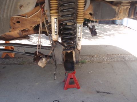 1994 Ford Bronco - Close-up of a vehicle's front suspension system, showing lifted components and rust.
