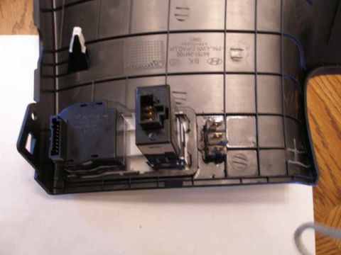 2010 Hyundai Genesis - Close-up of automotive interior trim panel with electrical components and part numbers.