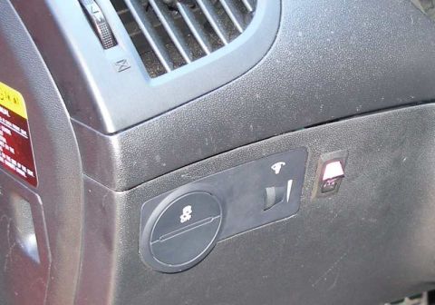 2010 Hyundai Genesis - Close-up of a car's interior dashboard, showing an air vent, a traction control switch, and an illuminated pink toggle switch.