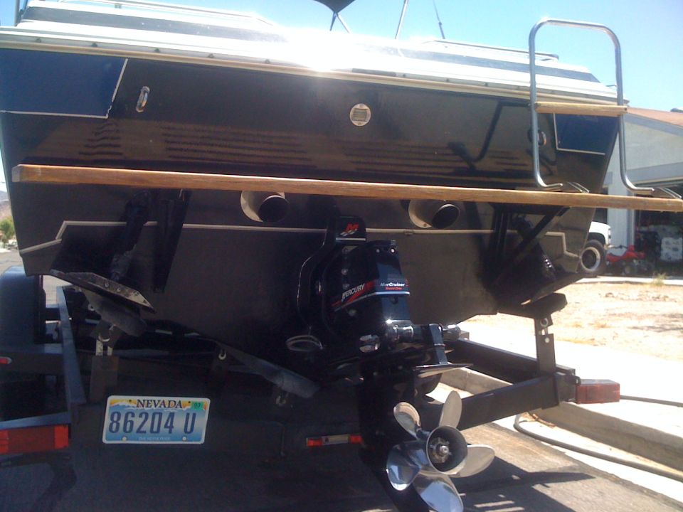 Stern of dark boat on trailer with MerCruiser sterndrive, prop, and Nevada plate 86204 U