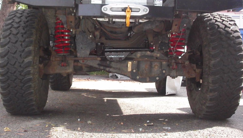 An example of having good steering angles on a TTB suspension. Tie rods are nearly horizontal (inline with the beams). This puts the movement of the steering in proper phase with that of the axle beams, nearly eliminating any bumpsteer (this holds true for custom setups like here, as well as with the stock "y" linkage). 
It's unfortunate too many kits on the market don't maintain correct geometry of the steering, and is a huge source of the problems commonly seen on these suspensions (poor handling, tire wear, etc.).
Proper steering is a must with flexible coils such as the XJ coils...  (maybe this is why TTB lift coils are made so stiff? Companies using them in an attempt to cover up their engineering failure by restricting the suspension's movement as much as possible??).
