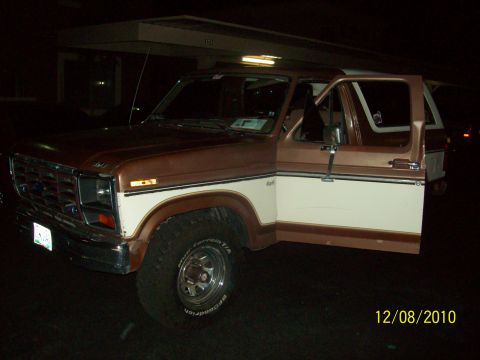 1985 Ford Bronco - This 1980s Ford Bronco has a two-tone paint scheme and the driver's door is open.