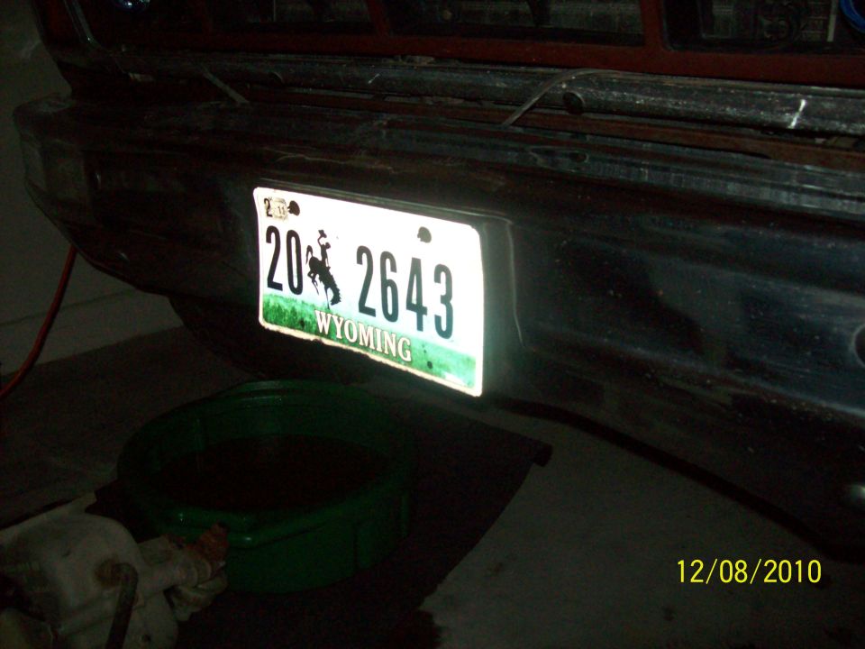 Rear bumper of a vehicle with a Wyoming license plate reading 20 2643. A green drain pan is underneath