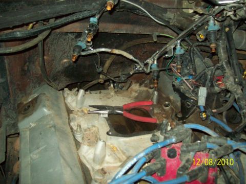 1985 Ford Bronco - Close-up view of an engine compartment showing fuel injectors, wiring harnesses, and a pair of pliers, with a date stamp visible.