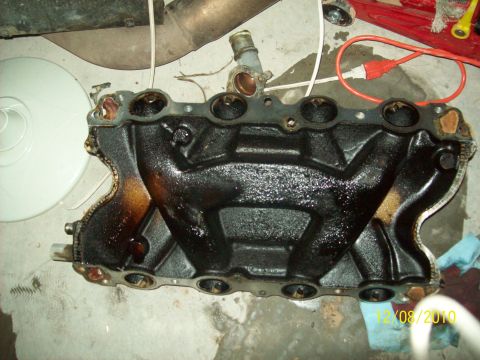 1985 Ford Bronco - This is a close-up of an engine intake manifold, covered in oil and grime, with a date stamp visible.