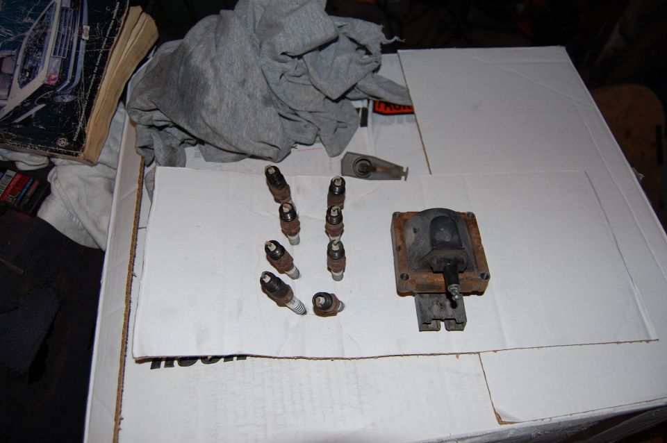 Old Autolite Platinum plugs, coil, and rotor removed. The coil has a large pit worn in the terminal.