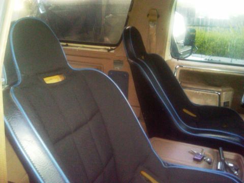 1986 Ford Bronco - Bucket seats with blue trim are visible inside the 1986 Ford Bronco.