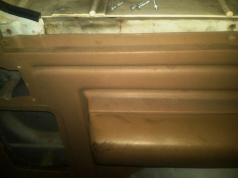 1986 Ford Bronco - Close-up view of a vehicle's interior door panel, showing its textured surface and construction details.