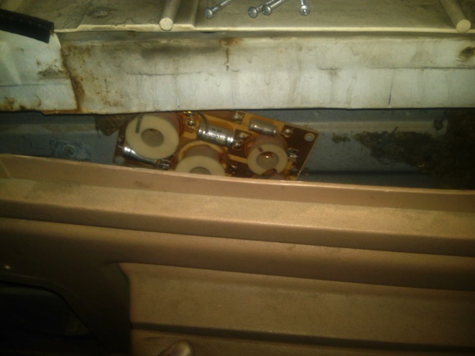 Electronic circuit board with capacitors and coils visible inside a vehicle's interior