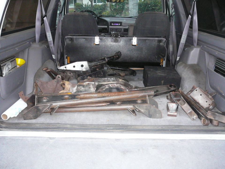 Interior view of vehicle cargo area with suspension parts