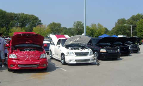 2007 Ford Mustang - Several Ford F-150 Lightning trucks are parked in a row with their hoods up.