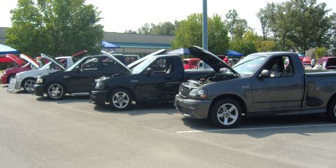 2007 Ford Mustang - A row of Ford F-150 Lightning pickup trucks are displayed with their hoods raised.