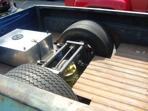 2007 Ford Mustang - The rear of a modified pickup truck shows a custom fuel tank and suspension system, with another vehicle in the background.