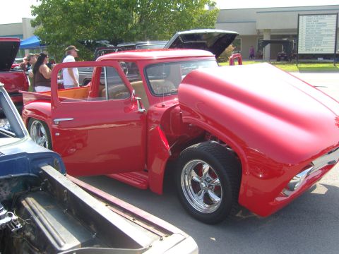 2007 Ford Mustang - This red 1956 Ford F-100 pickup truck is displayed with its hood open, revealing the engine bay.