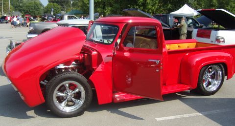 2007 Ford Mustang - Customized red pickup truck on display at a car show, hood and door open.
