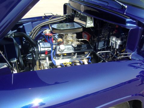2007 Ford Mustang - The engine bay of a custom blue vehicle, a polished Ford V8 engine with racing components.