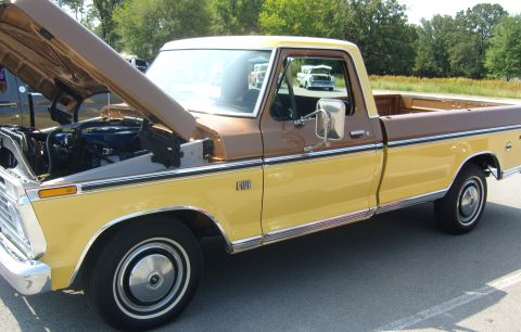 2007 Ford Mustang - A two-tone Ford F-100 pickup truck is parked outdoors with its hood up, and another truck is visible in the background.