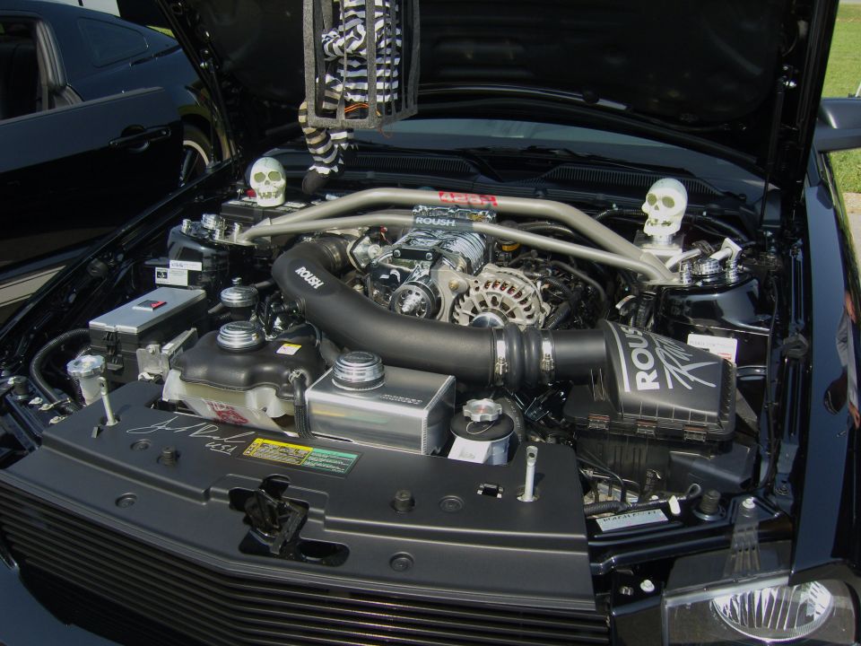 Black 2007 Ford Mustang engine bay with Roush supercharger and skull decorations