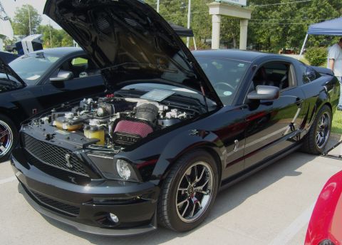 2007 Ford Mustang - A black Ford Mustang Shelby GT500 is displayed with its hood open, revealing the engine compartment.