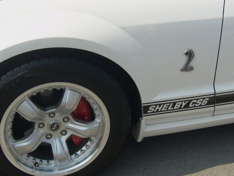 2007 Ford Mustang - Close-up of a white Shelby CS6 Mustang, showing the side stripe and a cobra emblem.