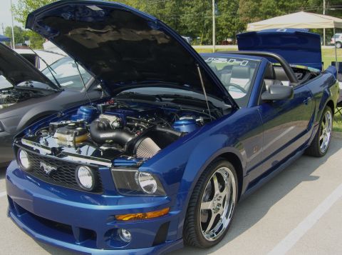 2007 Ford Mustang - A blue convertible with its hood open, revealing the engine and custom chrome wheels.