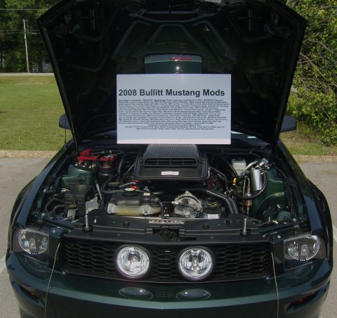 2007 Ford Mustang - A 2008 Ford Mustang Bullitt is displayed with its hood open, revealing the engine and a sign listing its modifications.